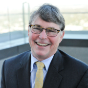 A man in suit and tie smiling for the camera.