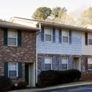 A row of brick houses with green shutters.