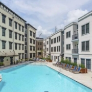 A large swimming pool in the middle of an apartment complex.