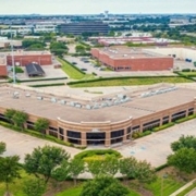 An aerial view of a parking lot with lots of trees.