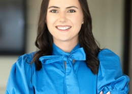 A woman in blue shirt with arms crossed.