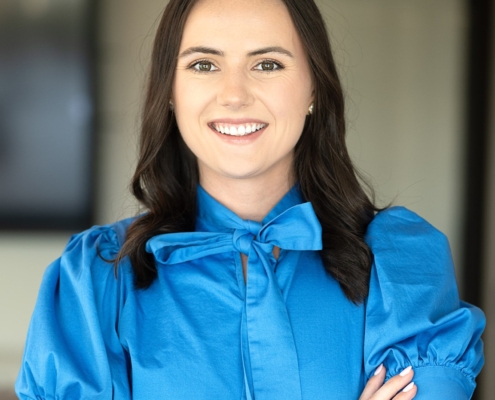 A woman in blue shirt with arms crossed.