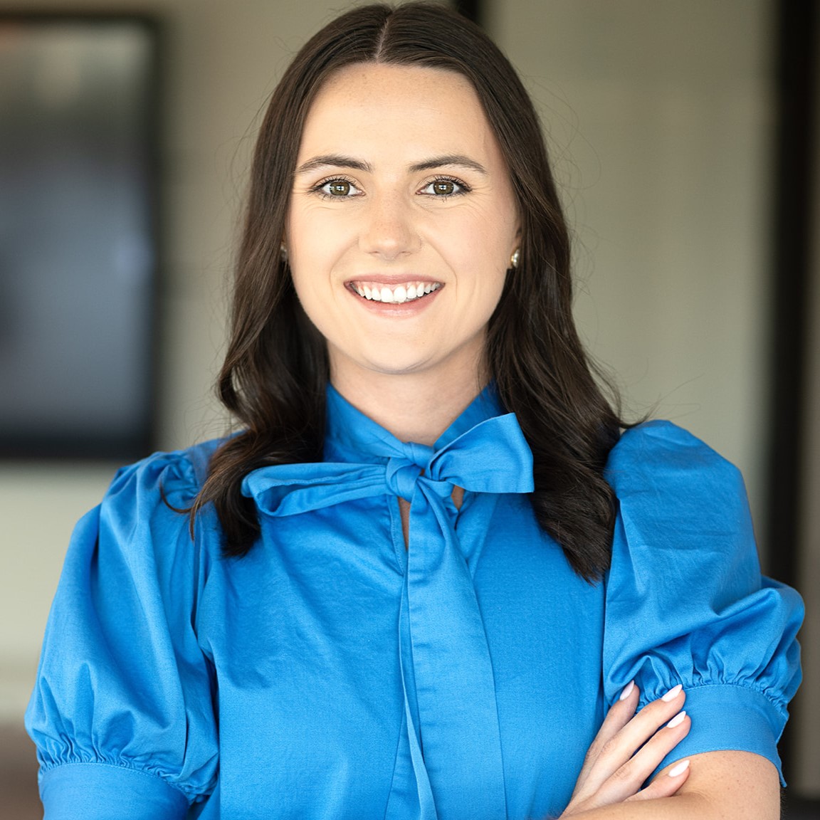 Erin Green A woman in blue shirt with arms crossed.