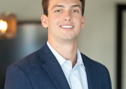 A man in a suit and tie smiling for the camera.