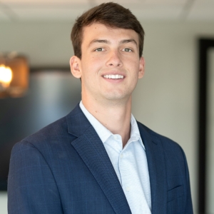 A man in a suit and tie smiling for the camera.