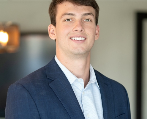 A man in a suit and tie smiling for the camera.
