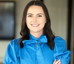 A woman in blue shirt with arms crossed.